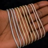 Close-up of a 3mm 14K gold color moissanite tennis bracelet on a woman’s wrist with hip hop streetwear styling.