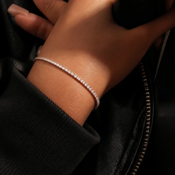 Close-up of a 3mm 14K gold color moissanite tennis bracelet on a woman’s wrist with hip hop streetwear styling.
